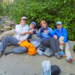 A group of 4 ladies relaxing on a large boulder.