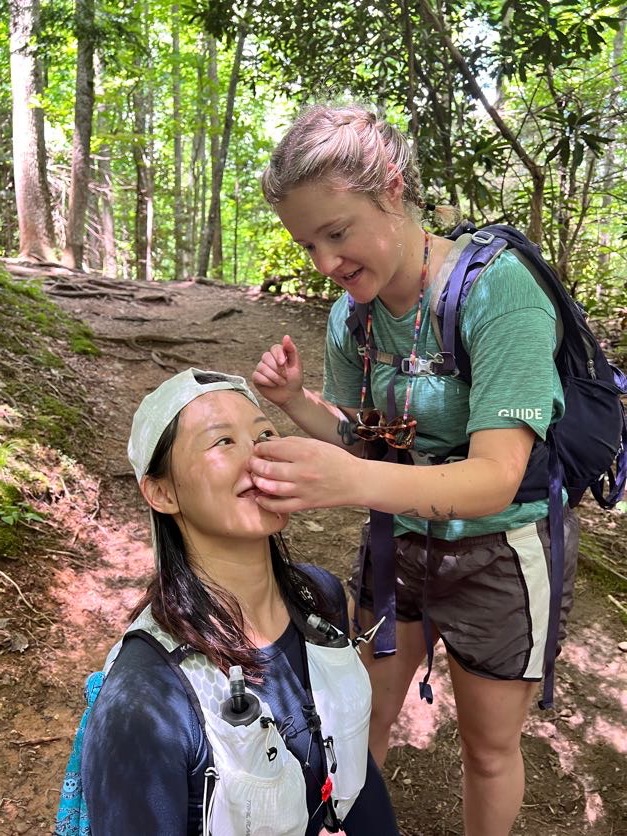 Guide putting a snail on another persons nose playfully.